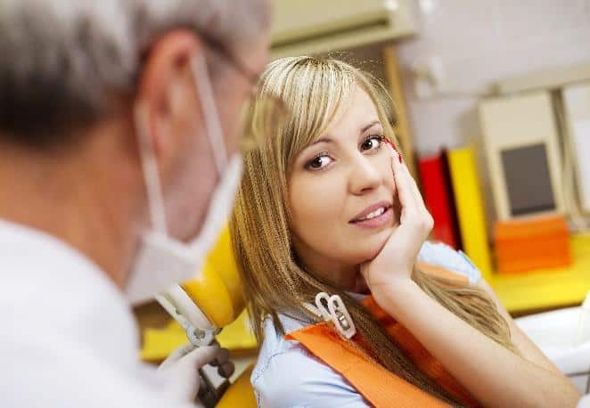 Young woman smiling at dentist during consultation in modern dental office.