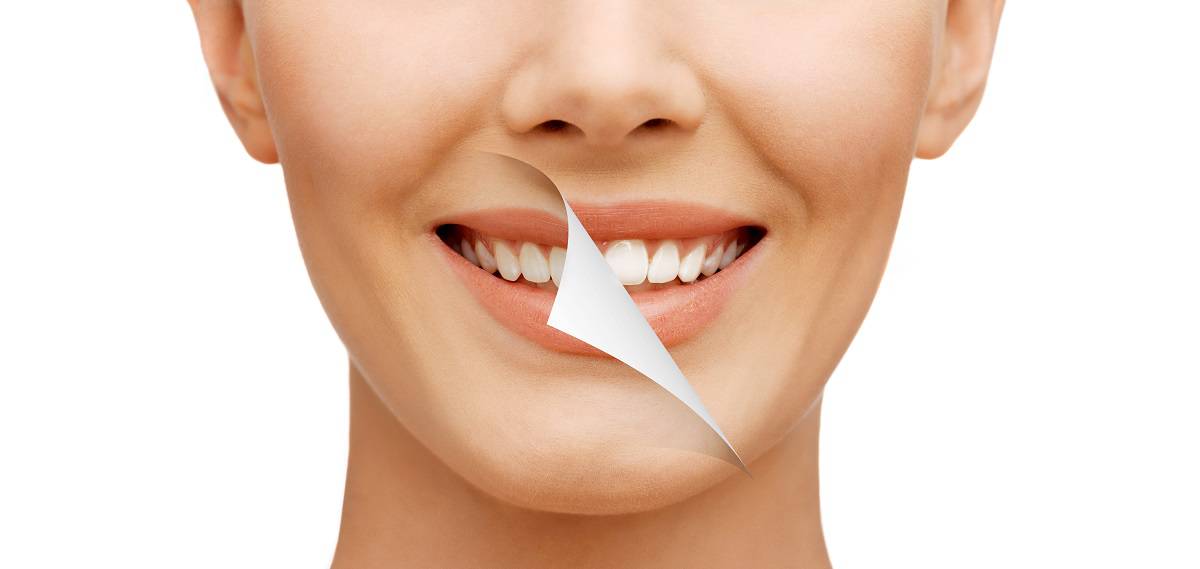 Person holding a toothbrush near teeth, demonstrating dental hygiene and oral care practices.